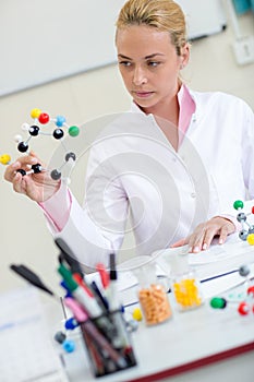 Chemistry teacher observing molecular structure in classroom