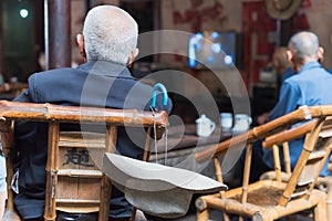 Senior chinese people watching TV in an old tearoom