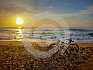 Chennai, India - April 15th 2022: Hybrid Road Cycle Parked on the beach sand during sun rise time. Hybrid 7 Speed Gear Cycle