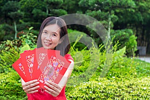 Cheongsam asian woman with red envelopes in hand, Gong xi fatt cai