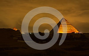 The Cheops pyramid from Giza at night. Giza pyramid illuminated at night seen from the roof of a hotel. Pyramid of Khufu