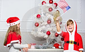 Cherished holiday activity. Kids in santa hats decorating christmas tree. Family tradition concept. Children decorating