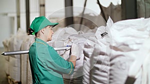 Cherkasy, Ukraine - August 24, 2018: woman, employee of agricultural enterprise, fills out paper sheets on big bags in