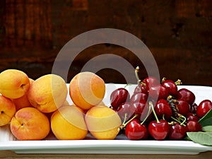 cherries and apricots on a tray