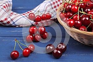 Cherries in a basket on a blue wooden background