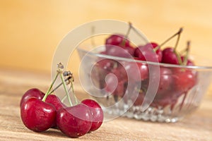 Cherries in a bowl, in front a small cluster, passion red