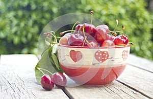 Cherries in a bowl on old wood photo