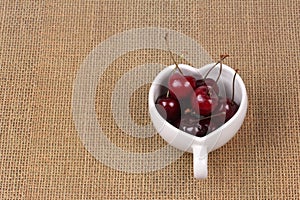 Cherries Chile and Heart-shaped mug on sackcloth.
