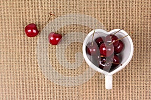 Cherries Chile and Heart-shaped mug on sackcloth.