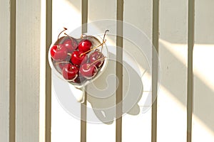 Cherries Chile in Heart-shaped mug on wood .