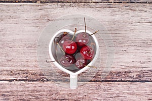 Cherries Chile and Heart-shaped mug on wooden.