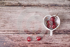 Cherries Chile and Heart-shaped mug on wooden.