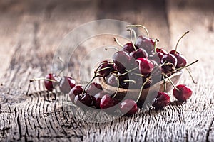 Cherries. Fresh sweet cherries. Delicious cherries with water drops in retro bowl on old oak table