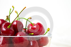 Cherries in glass dish. Cherry on wood and white background. - healthy eating and food concept