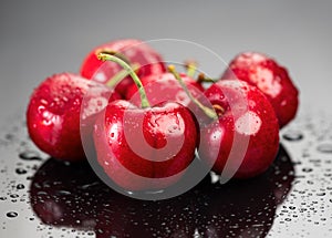 Cherries on gray background. Fresh ripe Cherry berries close-up. Organic red cherries with water drops