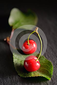 Cherries with leaf on ardesia plate