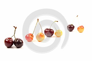 Cherries lying in pairs on white background