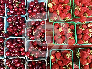Cherries and strawberries in baskets for sale at farmer's market