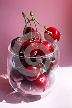 Cherries in transparent bowl, pink background. Red cherry. Fresh cherries. healthy food concept