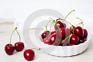 Cherries in white bowl. Cherry on white background. - healthy eating and food concept