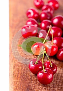 Cherries on wooden table with water drops