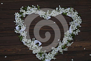 cherry blossom heart shaped decoration on dark brown wooden background