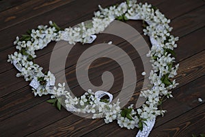 cherry blossom heart shaped decoration on dark brown wooden background