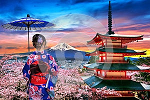 Cherry blossoms in spring, Asian woman wearing japanese traditional kimono at Chureito pagoda and Fuji mountain at sunset in Japan photo