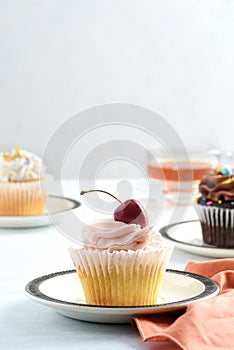 cherry buttercream cupcake on a plate with napkin
