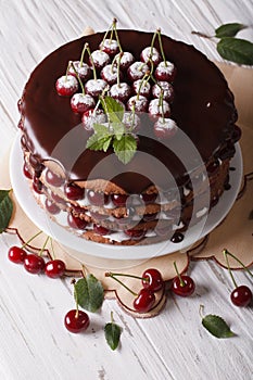 Cherry cake with chocolate icing on a plate. vertical