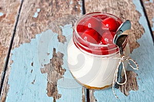 Cherry cheesecake in a mason jar with spoon