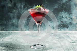 Cherry cocktail in martini glass with berries and mint leaves