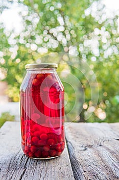 Cherry compote in the big glass jar. Homemade preserved cherries