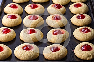 Cherry cookies on baking tray - delicious cherry topped cookies