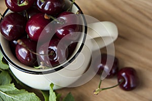 Cherry in cup on wooden table