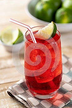 Cherry drink with lime wedges