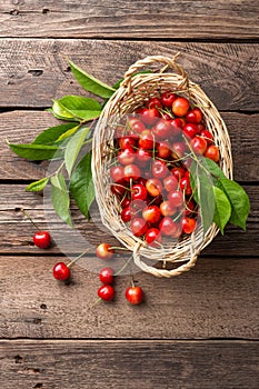 Cherry. Fresh sweet cherry with leaves in basket on wooden table