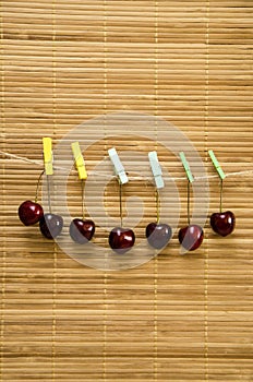 Cherry hanging on a clothespin on a rope