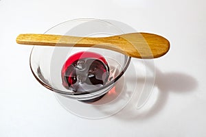 Cherry jam  in glass bowl and little wooden spoon