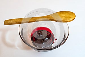 Cherry jam  in glass bowl and little wooden spoon