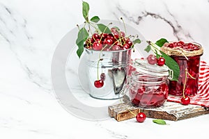 cherry jam in a jar and fresh berries on the table. Preserved organic food from garden on a light background. banner, menu, recipe