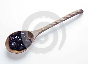 Cherry jam in wooden spoon isolated on white background