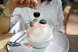 Cherry kakigori Bingsu - A bowl of Japanese shaved ice dessert flavor, topped with yogurt sauce and fresh cherry.