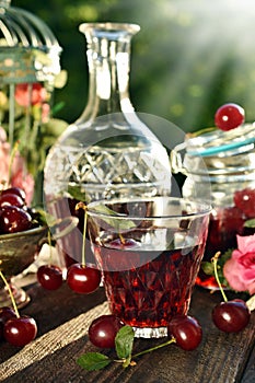 Cherry liqueur in crystal carafe and fresh fruits