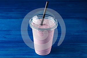 cherry milkshake in plastic glass on a dark background. cherry milkshake in takeaway cup