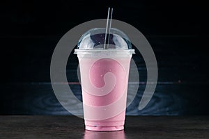 cherry milkshake in plastic glass on a dark background. cherry milkshake in takeaway cup