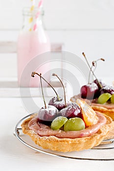 Cherry mini tarts with fruits and milk