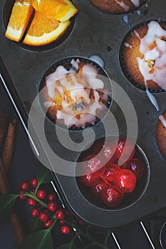 Cherry orange muffins in muffin baking pan; food background