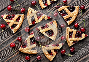 Cherry pie pieces on textured wooden background