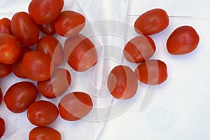 Cherry plum snack tomatoes on a white wooden background photo